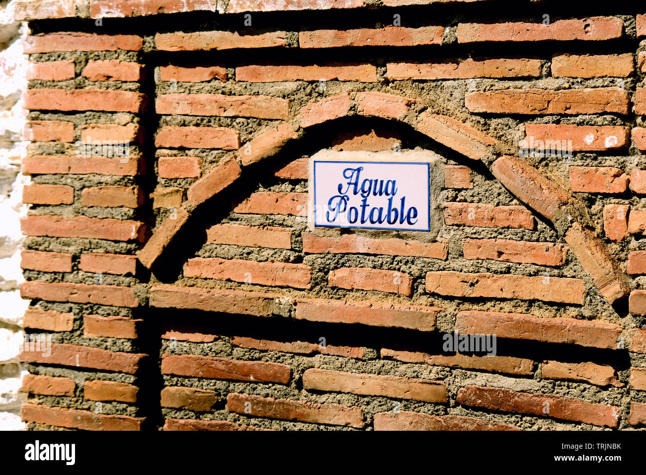 'Agua potable' sign on a tile over a water fountain for travelers in the town of Capileira in Las Alpujarras near Granada, Spain on a sunny day. Stock Photo