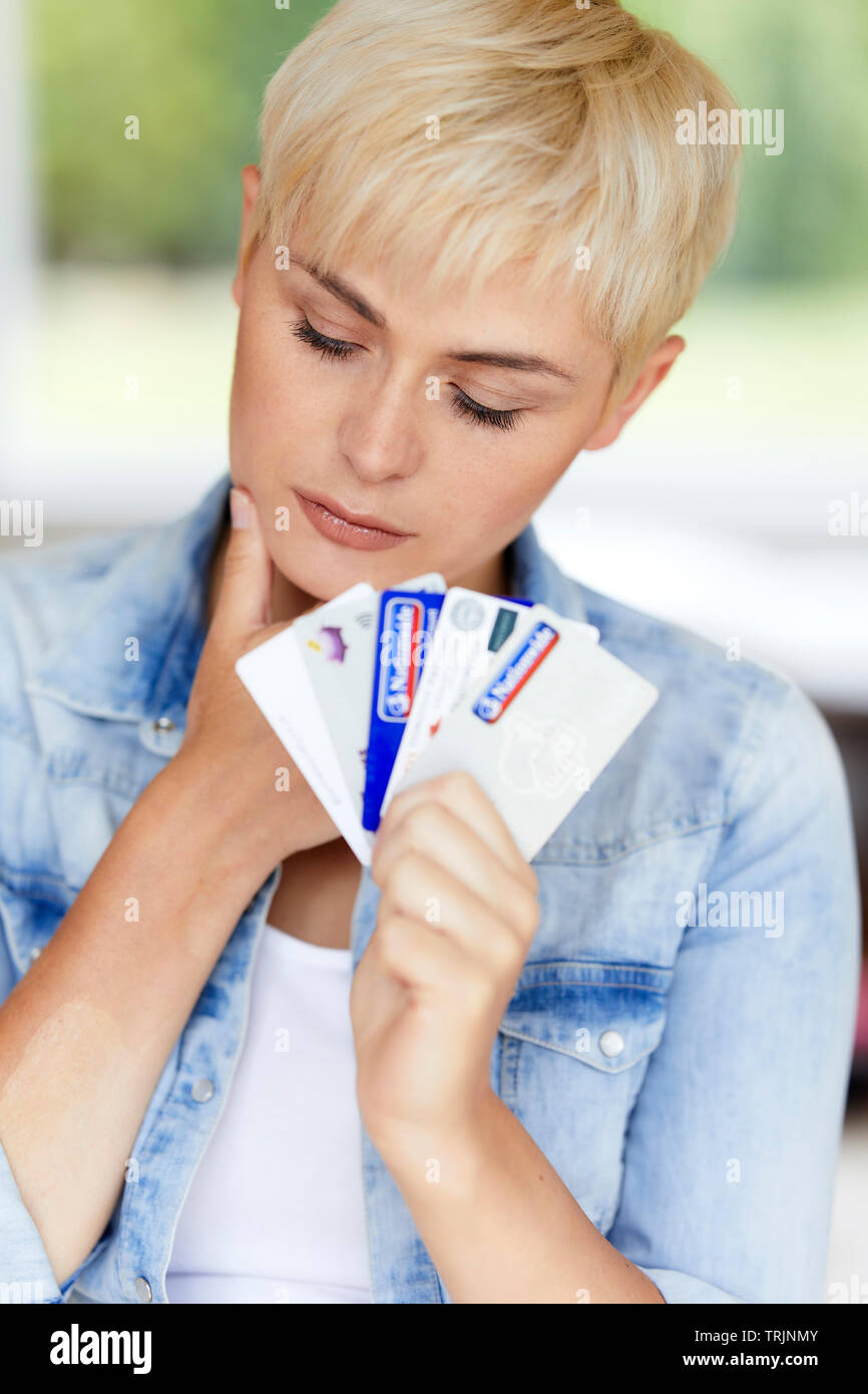 Woman looking concerned holding credit cards Stock Photo