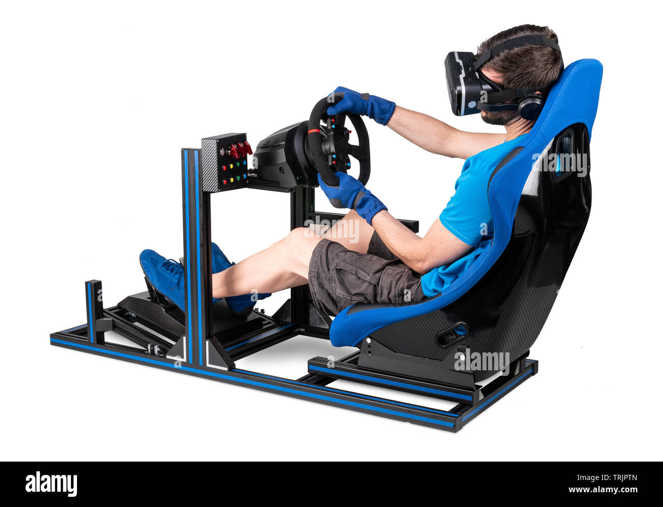 gamer in blue tshirt with VR virtual reality glasses training on simracing aluminum simulator rig for video game racing. Motorsport car bucket seat st Stock Photo