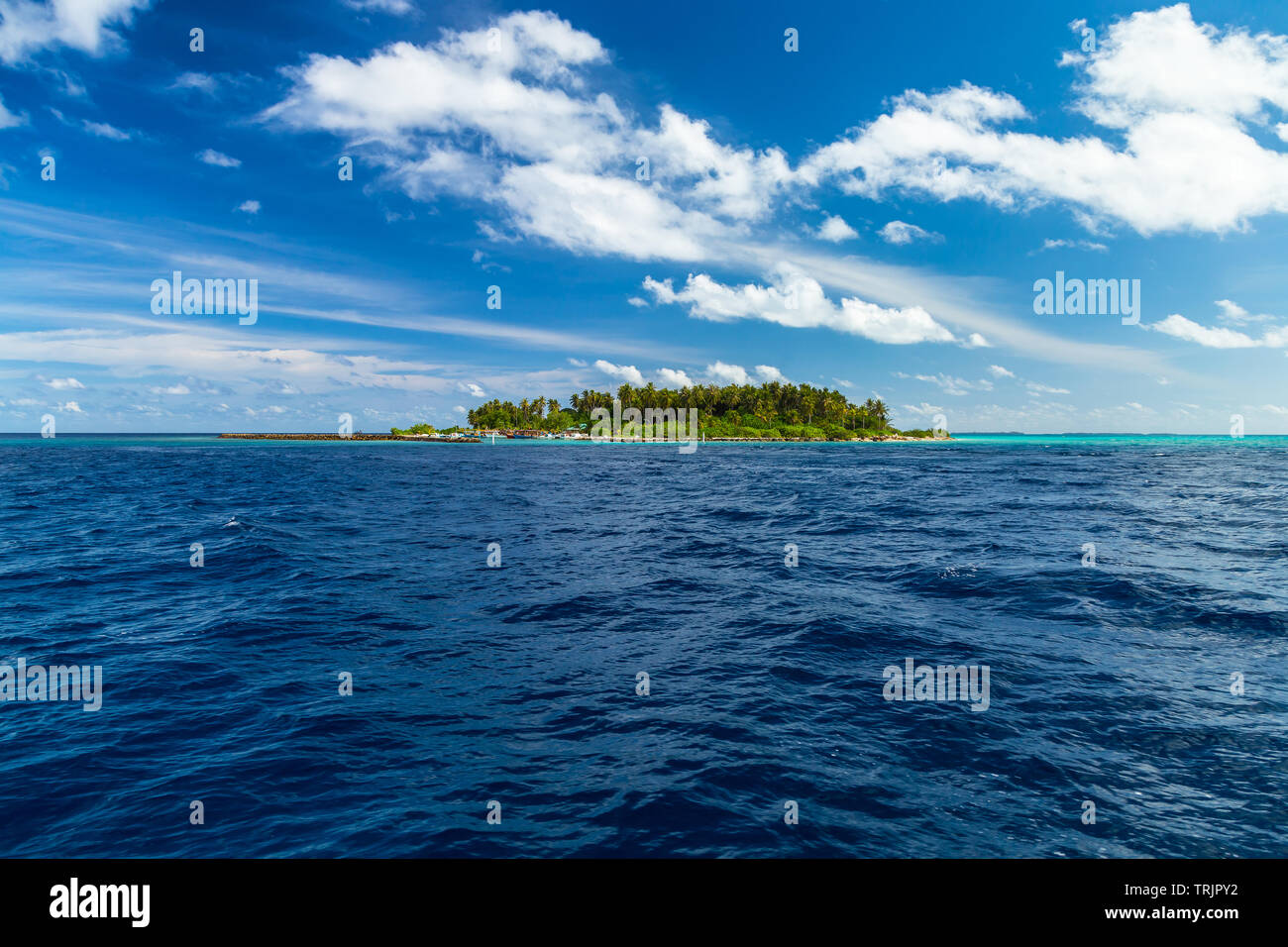 view from boat on sea ocean of tropical paradise maldives island resort with coral reef and turquoise blue ocean tourism blue summer sky background Stock Photo