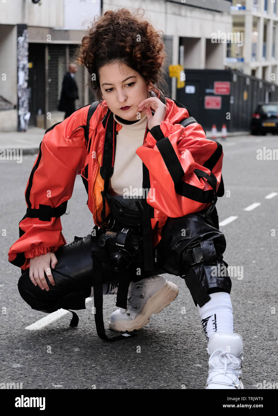 A guest at London Fashion Week posing outside Freemason's Hall for waiting photographers. Stock Photo