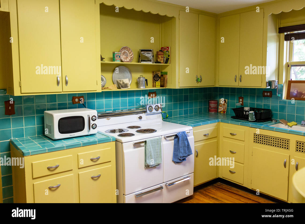 Retro 1940s Style Kitchen With Yellow Cabinets And Blue Tile At