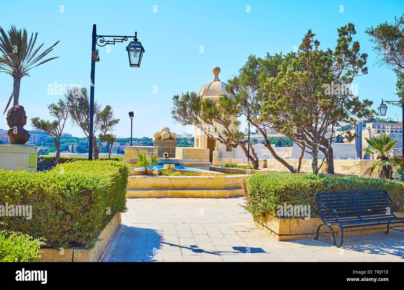 The scenic Gardjola Gardens, located on the upper level of fortress wall, decorated with stone cannon balls and trimmed bushes, Senglea, Malta. Stock Photo