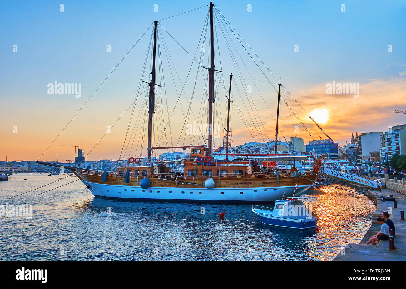 SLIEMA, MALTA - JUNE 19, 2018: Watch the sunset over the harbor, surrounded by modern residential and tourist neighborhoods, the ships and yachts are Stock Photo