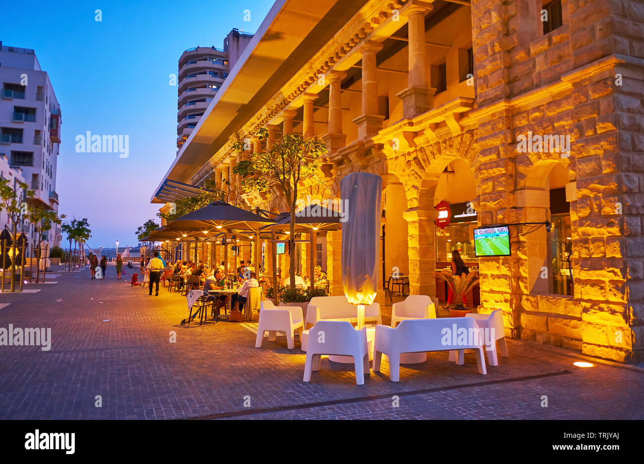SLIEMA, MALTA - JUNE 19, 2018: The line of outdoor cafes, stretching along the Tigne Point shopping mall, located on the same named peninsula, on June Stock Photo