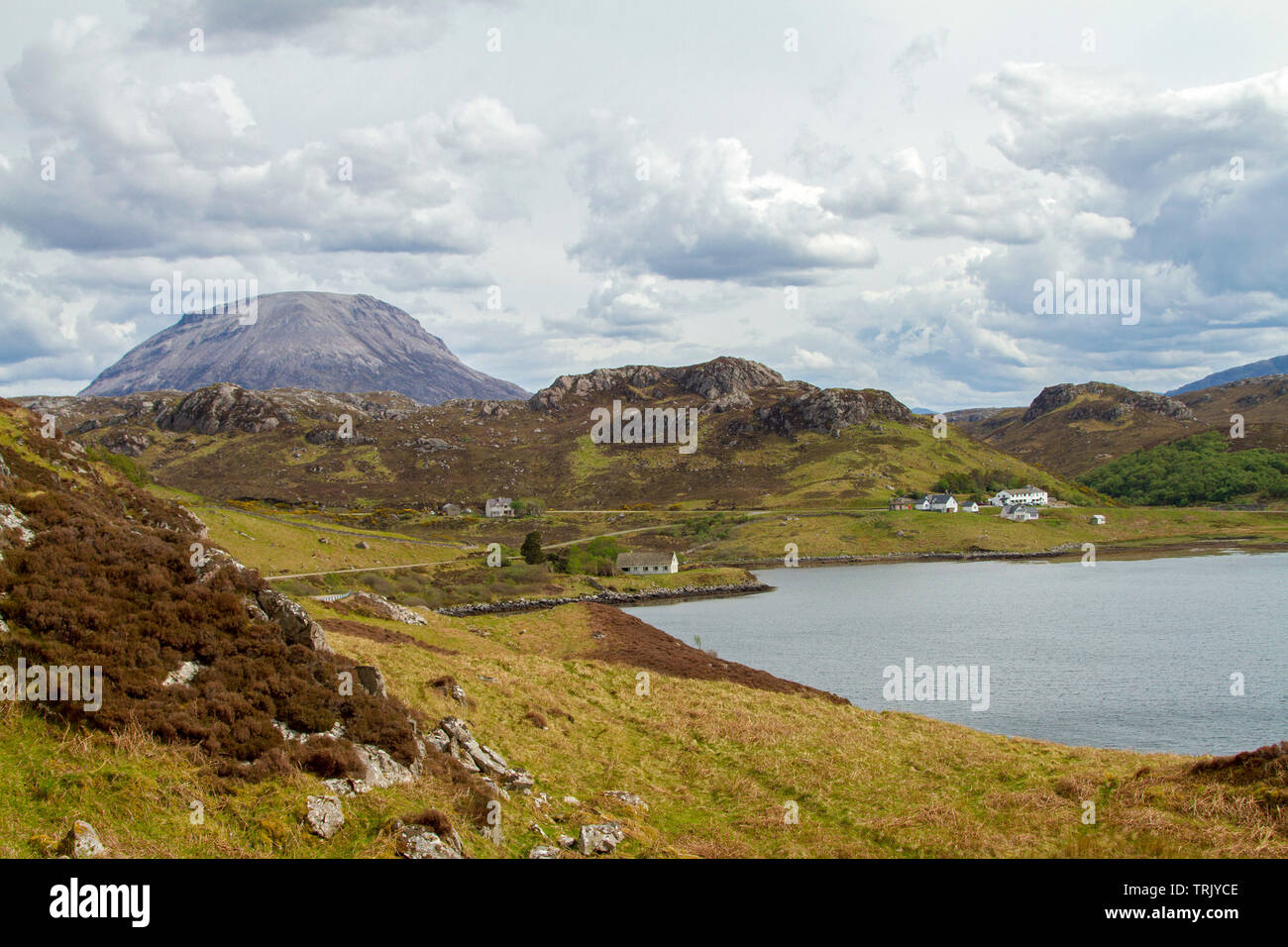 Scottish highland landscape with mountains rising above Loch Torridon and isolated farm houses among golden heather and grasses Stock Photo