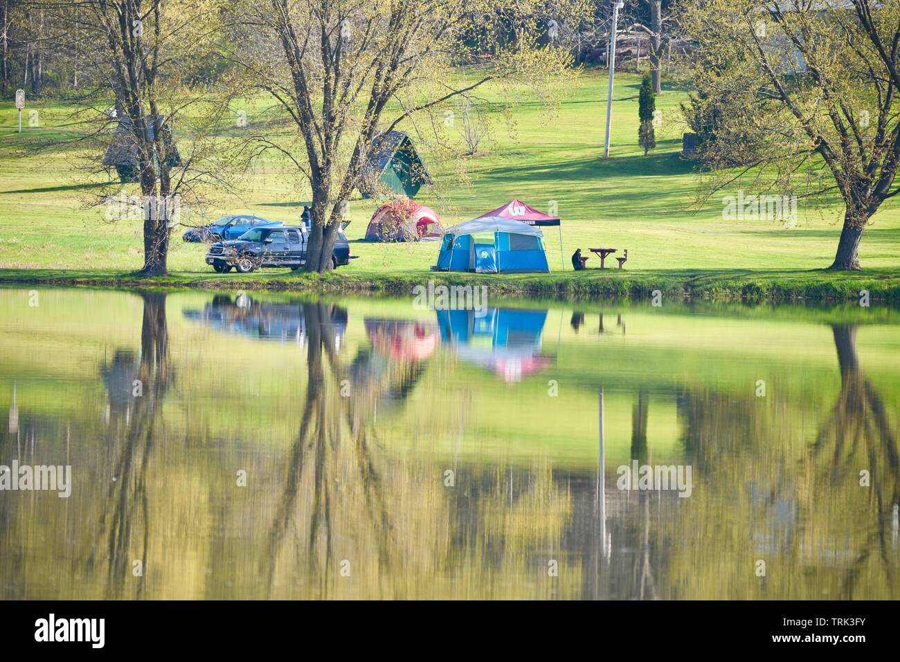 Bright green, springtime reflection of camping site along Bloody Lake, Blackhawk Memorial Park, a weekend adventure, outside Woodford, Wisconsin, USA Stock Photo