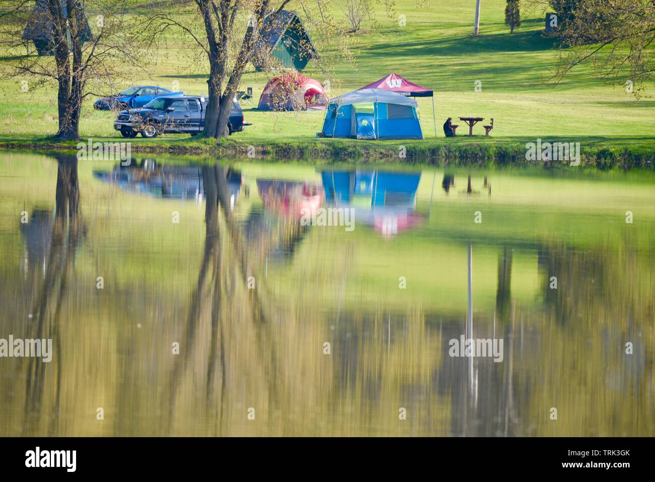 Bright green, springtime reflection of camping site along Bloody Lake, Blackhawk Memorial Park, a weekend adventure, outside Woodford, Wisconsin, USA Stock Photo