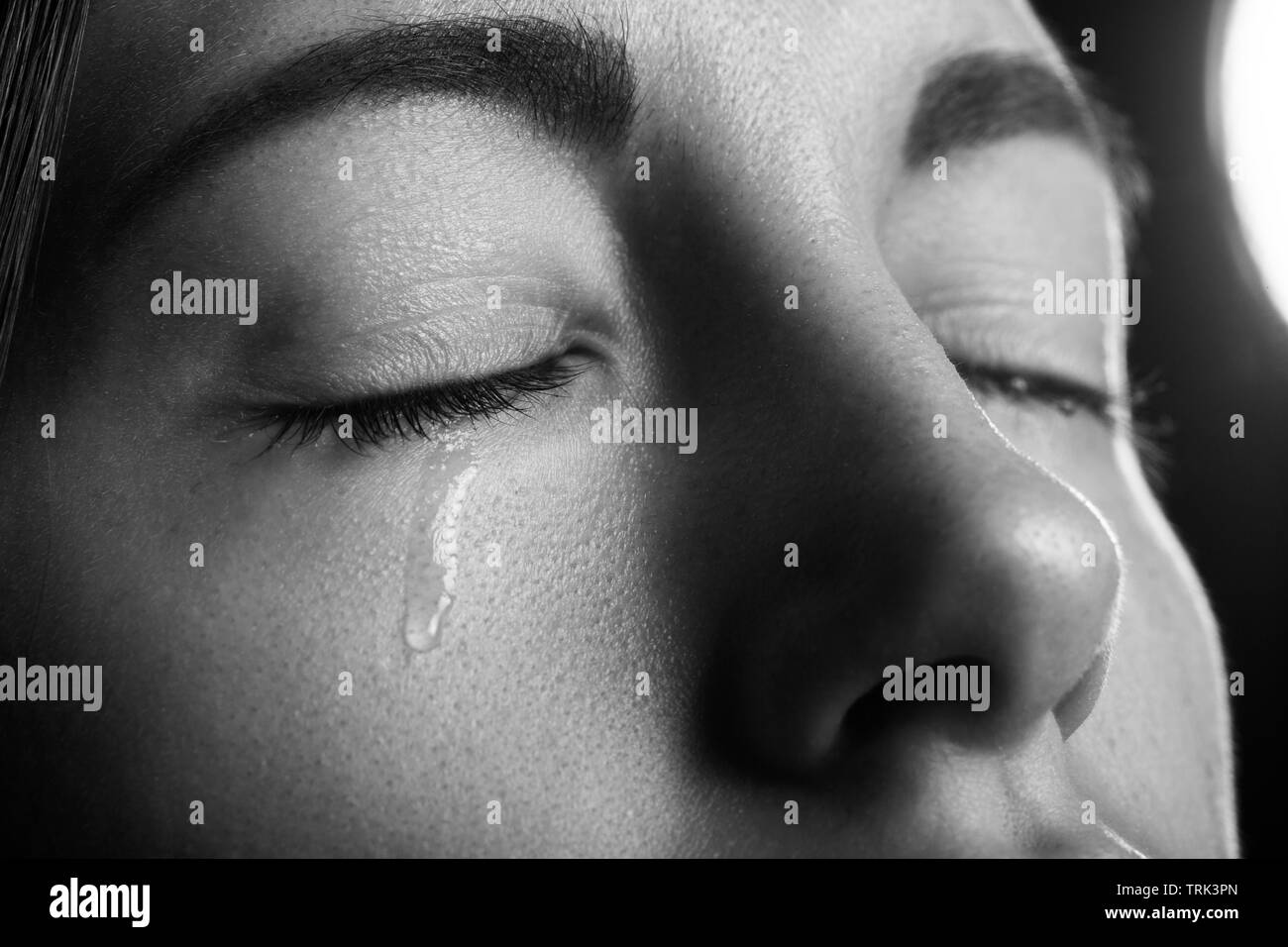 sad sad woman crying, closed eyes, closeup portrait, monochrome Stock Photo