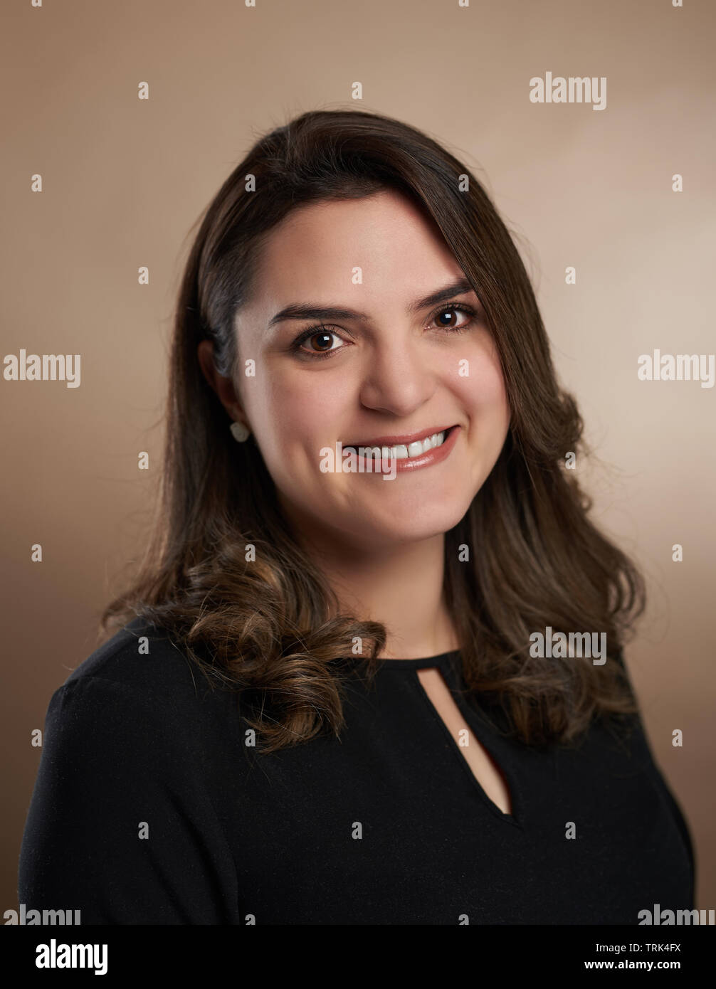 Close up portrait of brunette woman on brown studio background Stock Photo