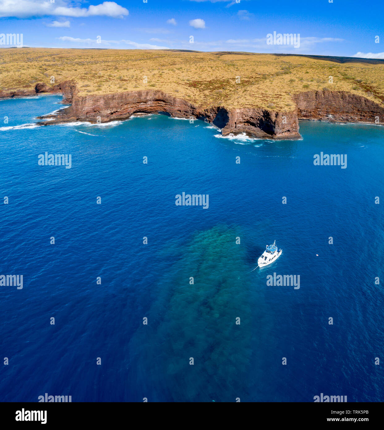 An aerial view of a dive charter vessel anchored at 2nd Cathedral, a popular site off the south shore of the island of Lanai, Hawaii, USA. Stock Photo