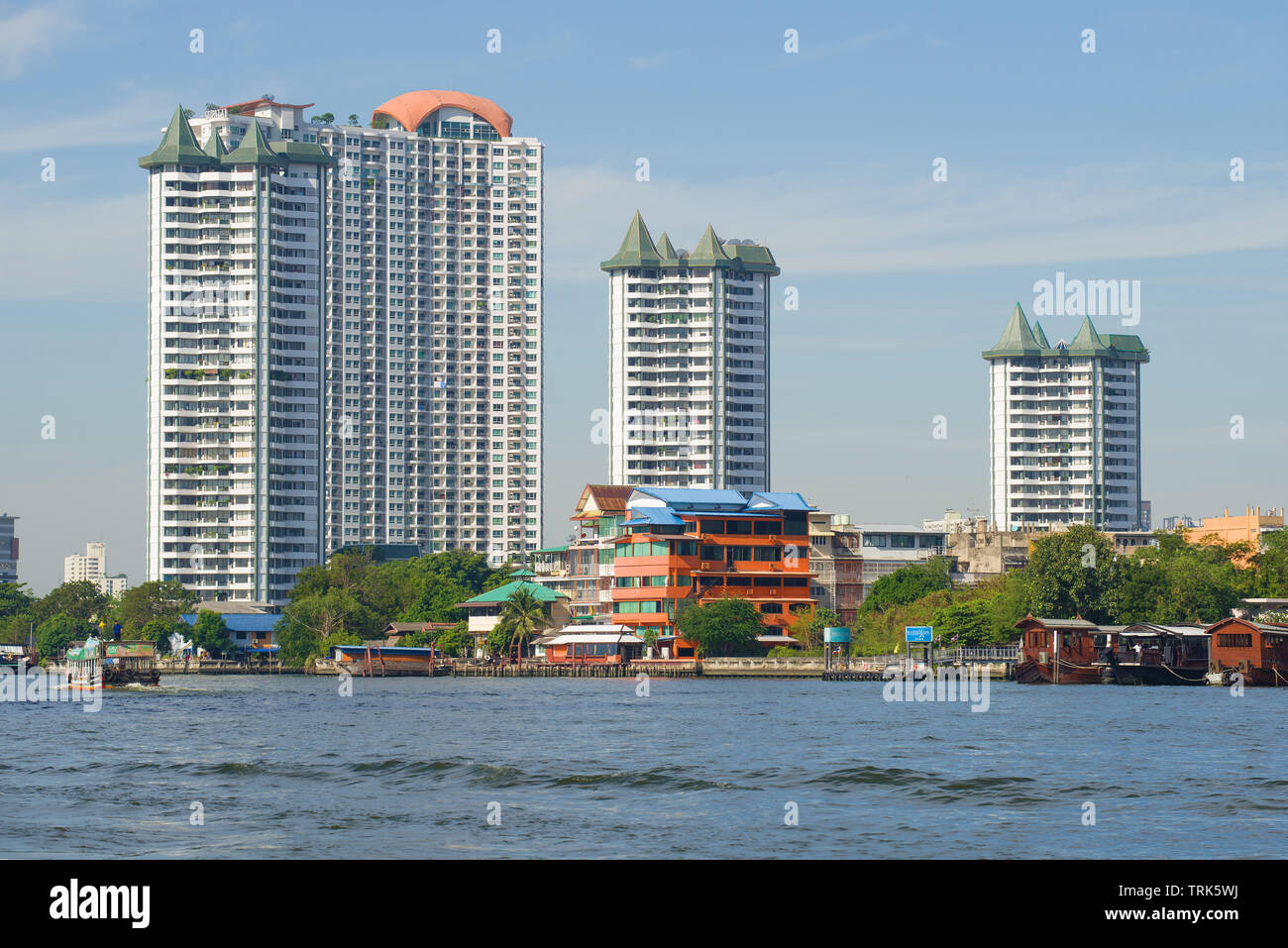 BANGKOK, THAILAND - JANUARY 02, 2019: View of new high-rise apartment buildings on the bank of the Chao Phraya River on a sunny day Stock Photo