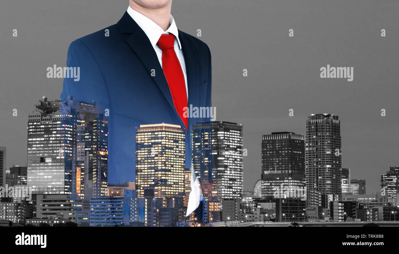 Business concept. Businessman in blue suit and red necktie, with double exposure panoramic business office buildings in the city in Japan Stock Photo