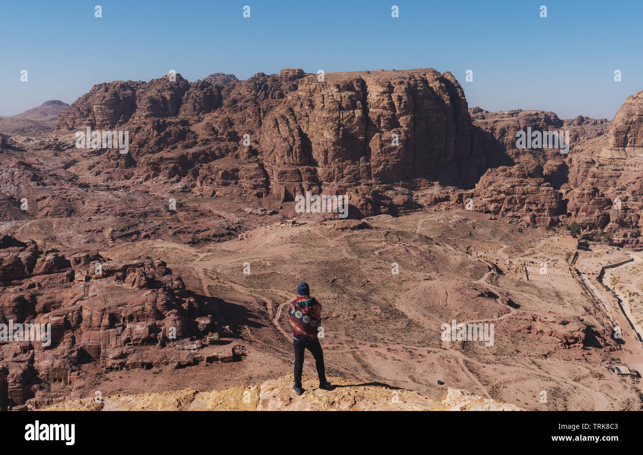 Traveler standing on cliff enjoying desert sightseeing in Petra, Jordan Stock Photo