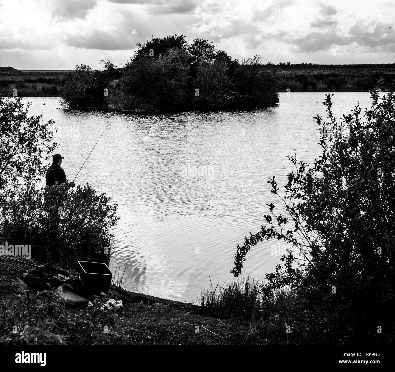Solitary man fishing Black and White Stock Photos & Images - Alamy