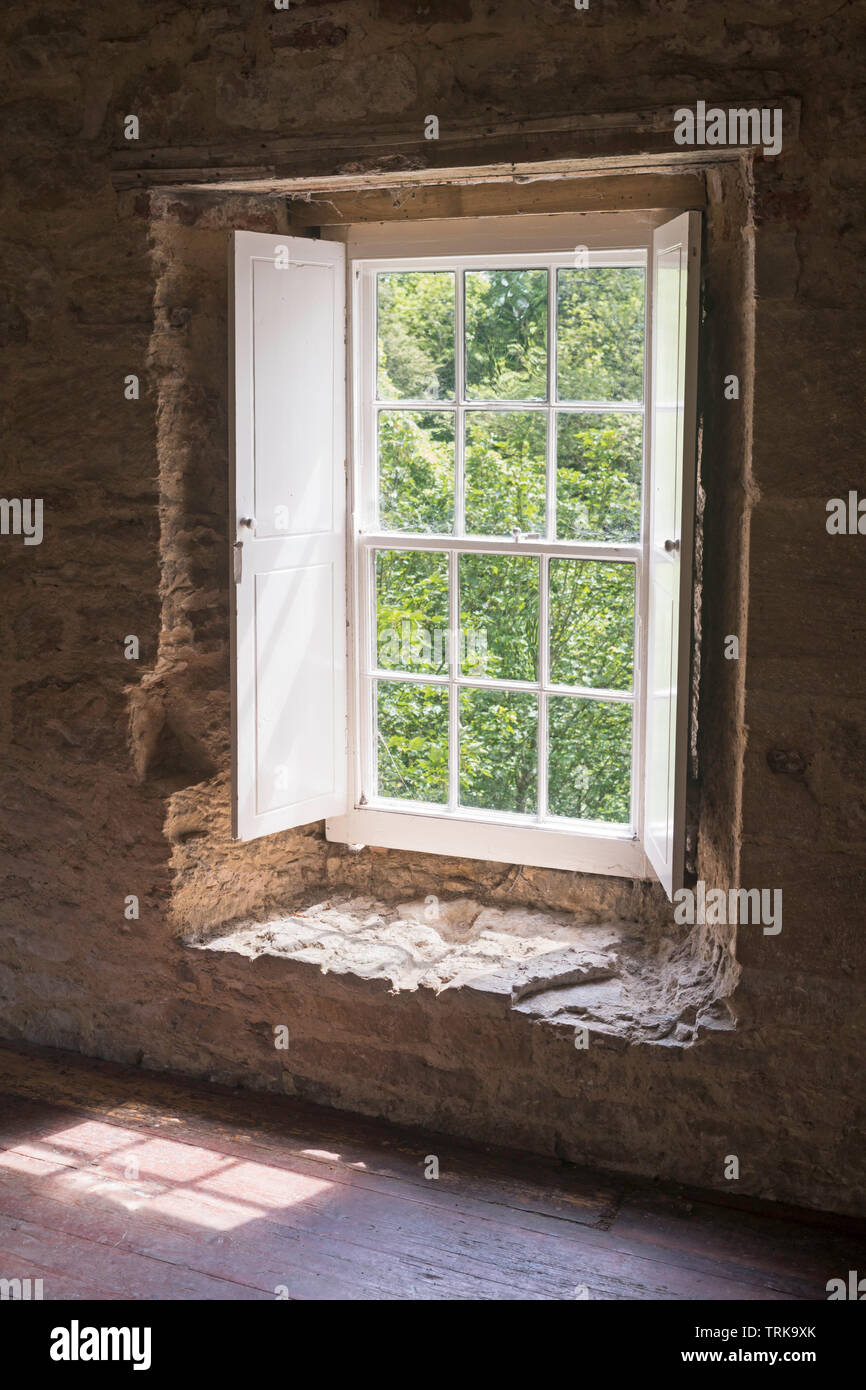 Looking out of a shuttered sash window in Aydon Hall, near Corbridge, Northumberland, England, UK Stock Photo