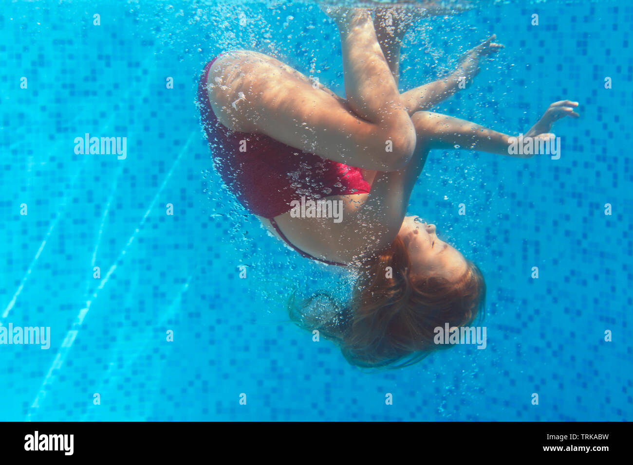 Little girl swimming underwater. Shot was taken with waterproof box Stock Photo