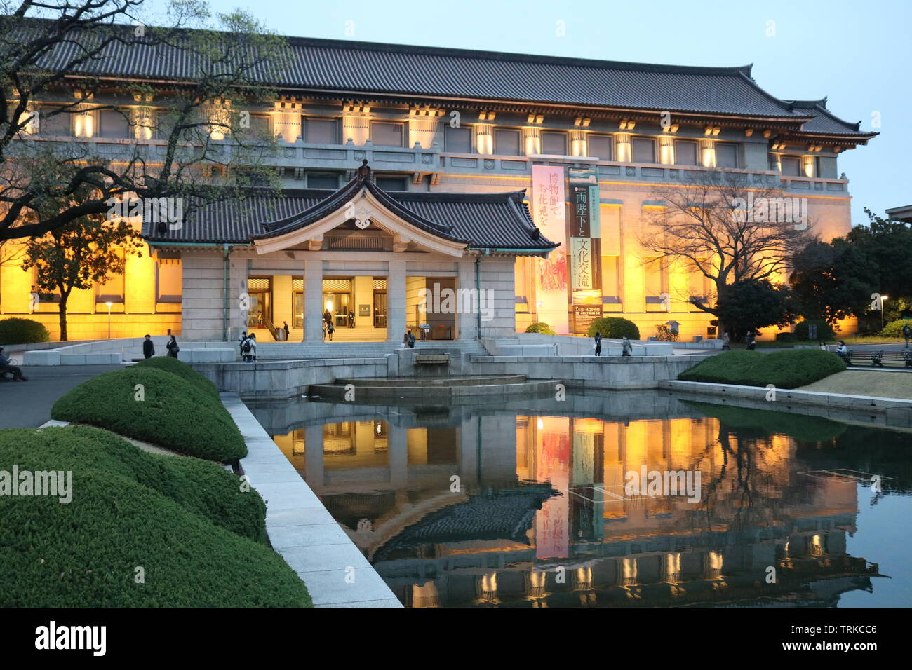 Early evening view of the front of Tokyo National Museum in Ueno Park in Tokyo with the lights of the building reflecting in the pond in front of it Stock Photo