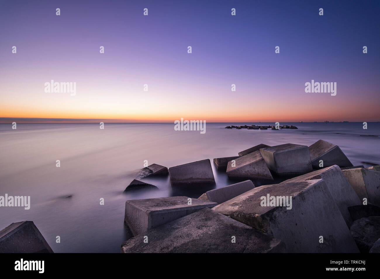 Beach at the blue hour seen from a breakwater Stock Photo