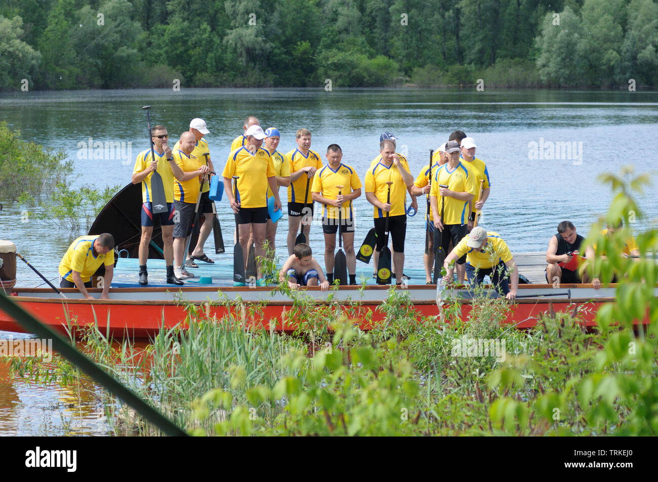 Oarsmen having break on a riverbank. Kiev oblast championship among amateurs. May 25, 2019. Kiev, Ukraine Stock Photo