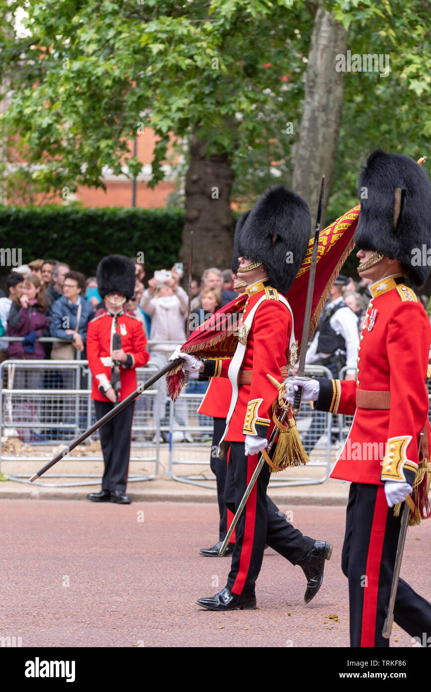 The Royal Family and massed bands and troops have traveled back down The Mall, London, UK from Horse Guards Parade for the Trooping of the Colour 2019. The Colour for this year is being trooped by 1st. Battalion Grenadier Guards. 2nd Lt. Robin Mackworth-Young as the Ensign Stock Photo