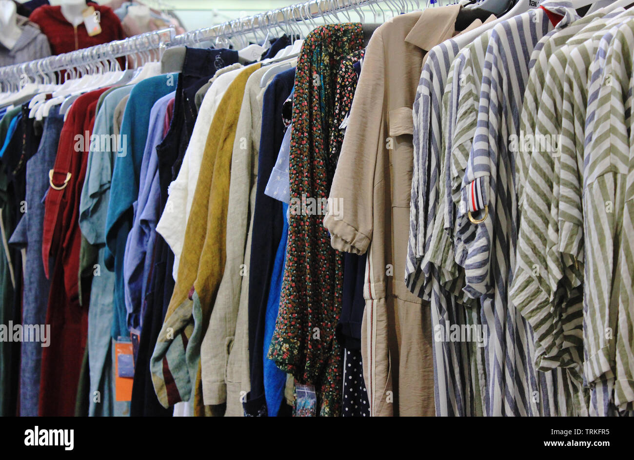 Colorful clothes for women and men at tje clothing store. Clothes on  hangers on display at shopping mall store Stock Photo - Alamy