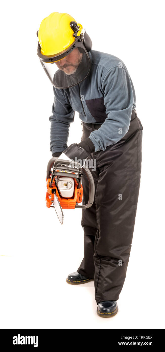 Man in safety gear demonstrating how to hold a chainsaw safely Stock Photo