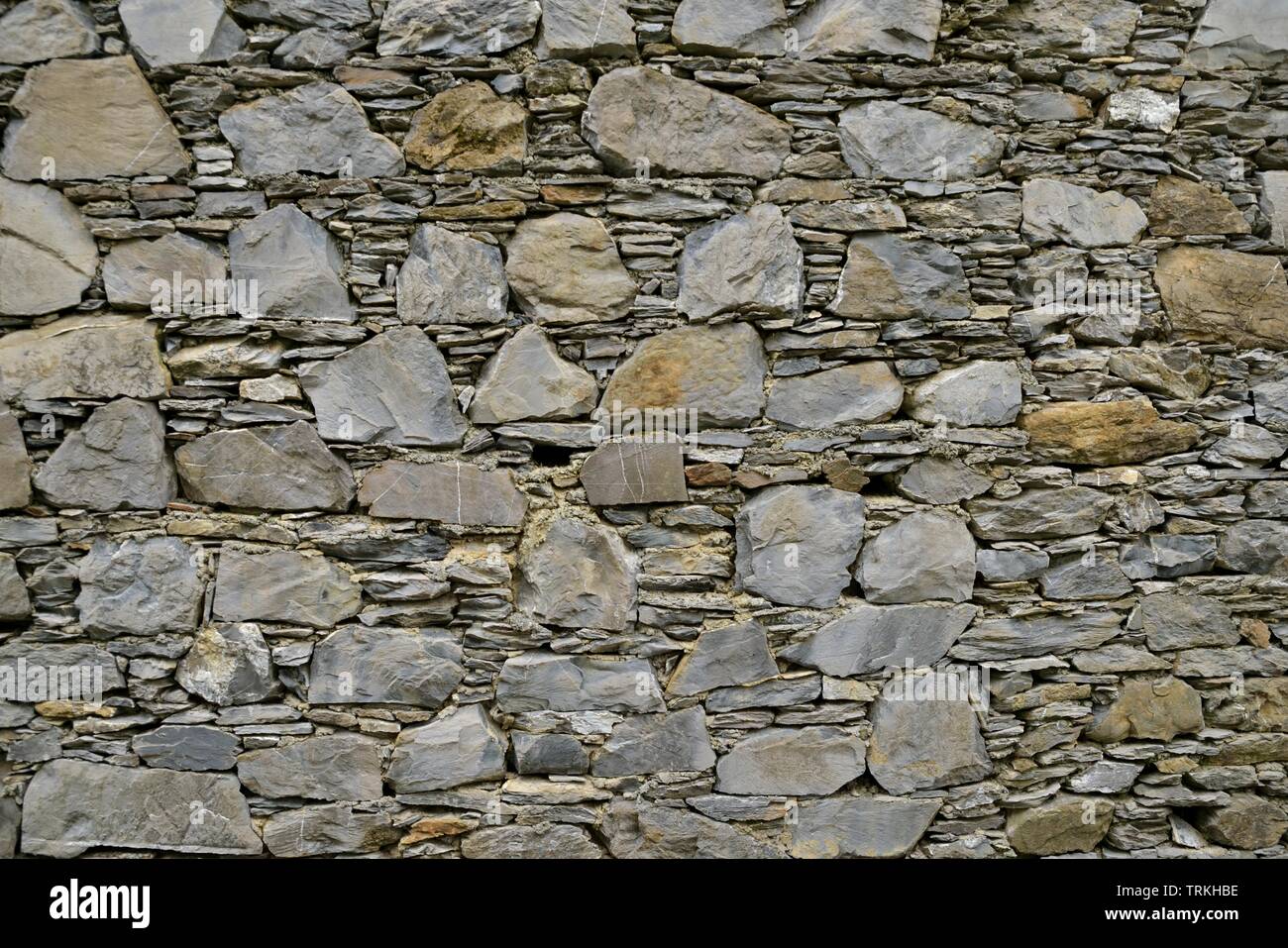 Weathered old stone wall background grey tone Stock Photo