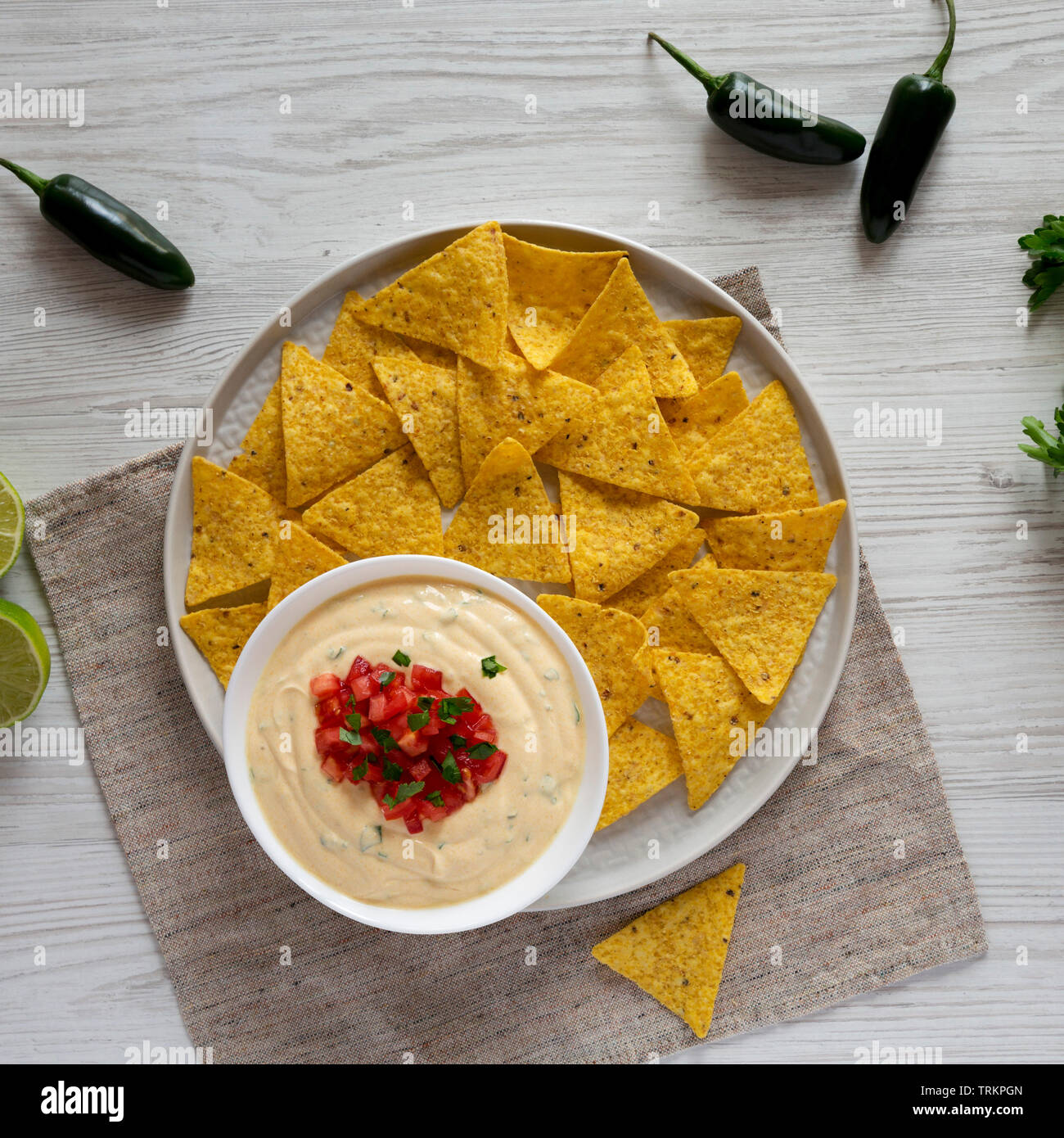 Homemade cheesy dip with nachos over white wooden surface, top view ...