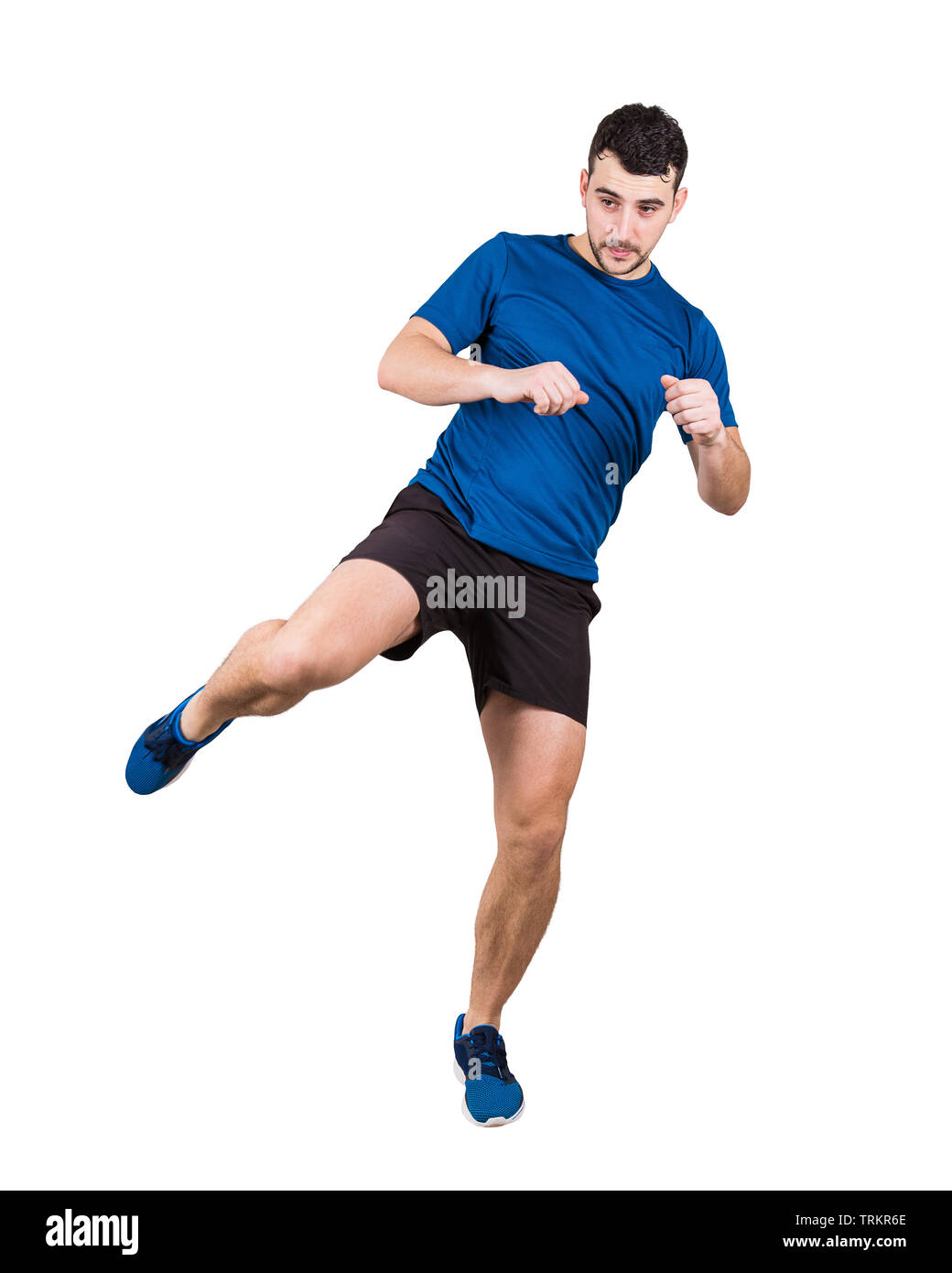 Full length portrait of young man athlete or fighter making a leg kick isolated over white background. Sporty caucasian guy boxer training. Stock Photo
