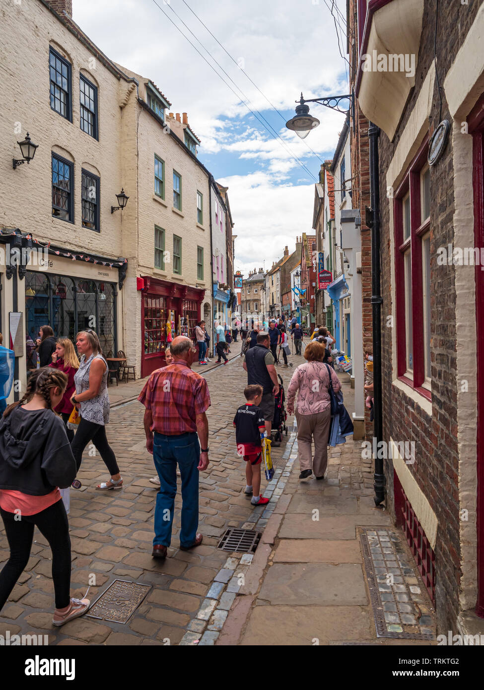 Tourists shopping on Church Street in Whitby North Yorkshire a traditional sea side town popular with tourists and holiday makers Stock Photo
