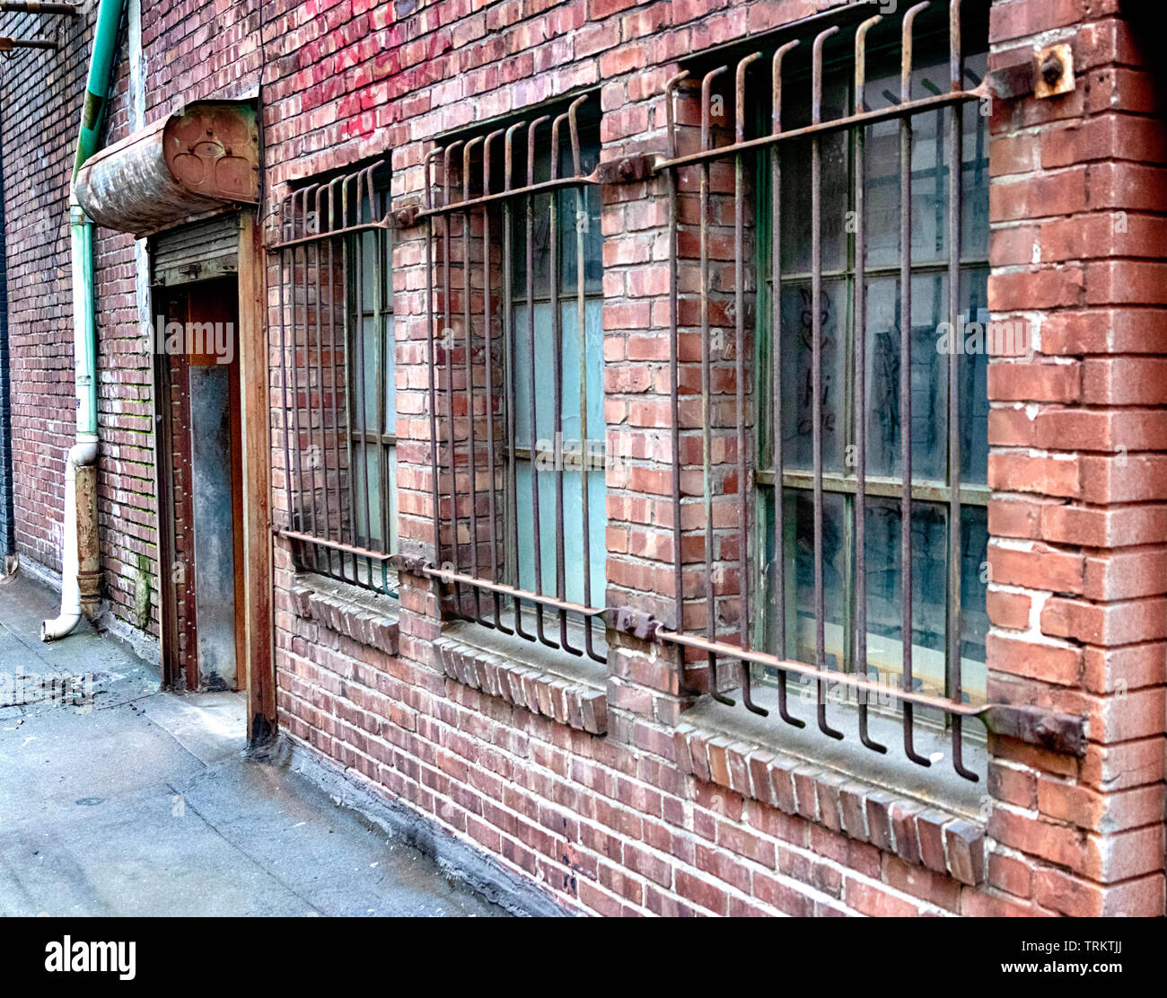 Perspective old brick building with steel bars covering the windows ...