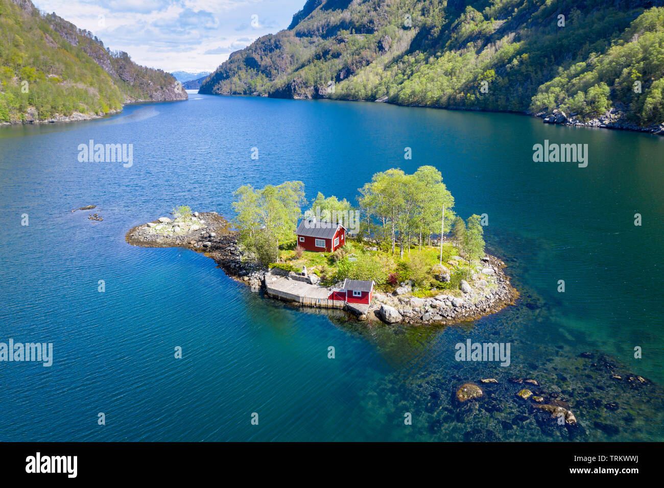 Typical red norwegian cottage on a little island in the fjord, shot from a drone, Lovrafjord, Norway Stock Photo