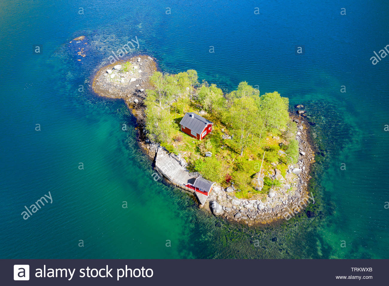 Typical Red Norwegian Cottage On A Little Island In The Fjord