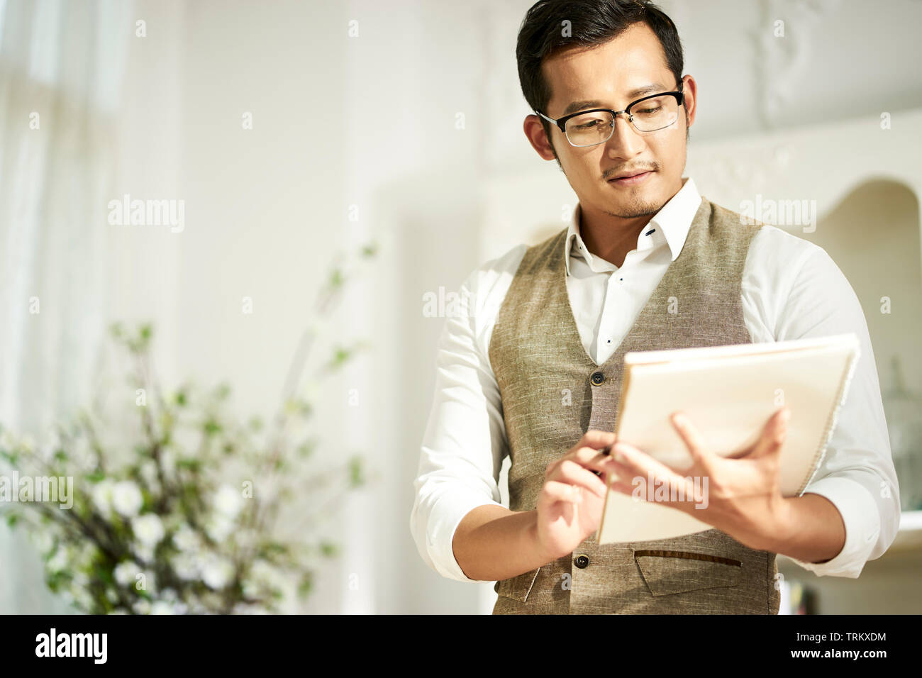 young asian architect designer looking at notes while working at home Stock Photo