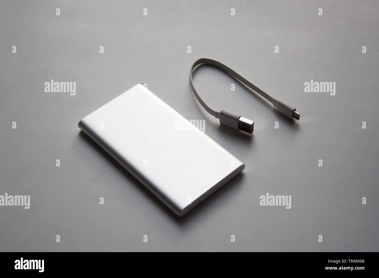 Portable aluminum power bank with USB cable isolated on white background Stock Photo