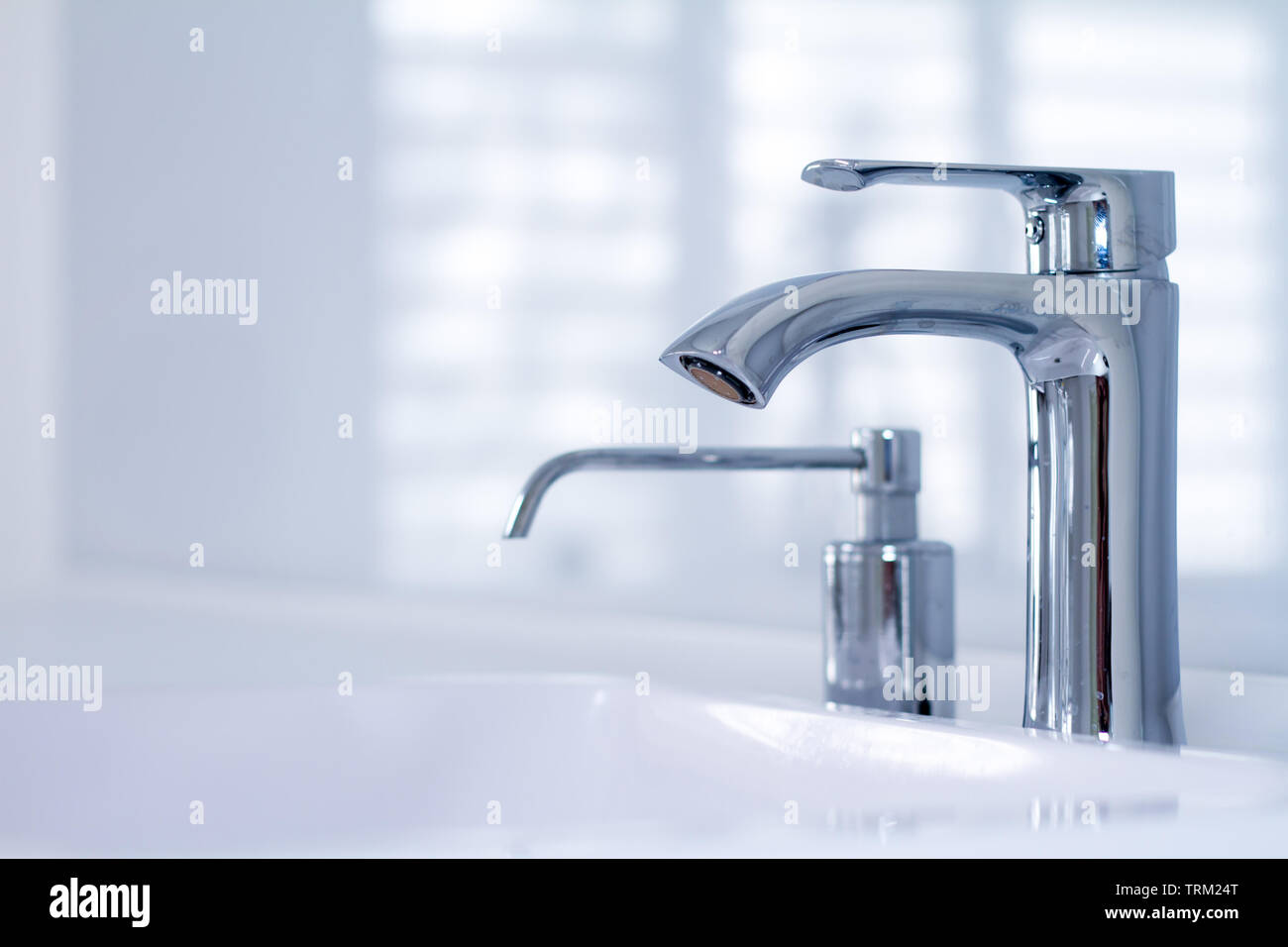 A modern water tap sink with faucet in minimalistic style and built-in soap  dispenser in expensive loft bathroom, soft focus, copyspace Stock Photo -  Alamy