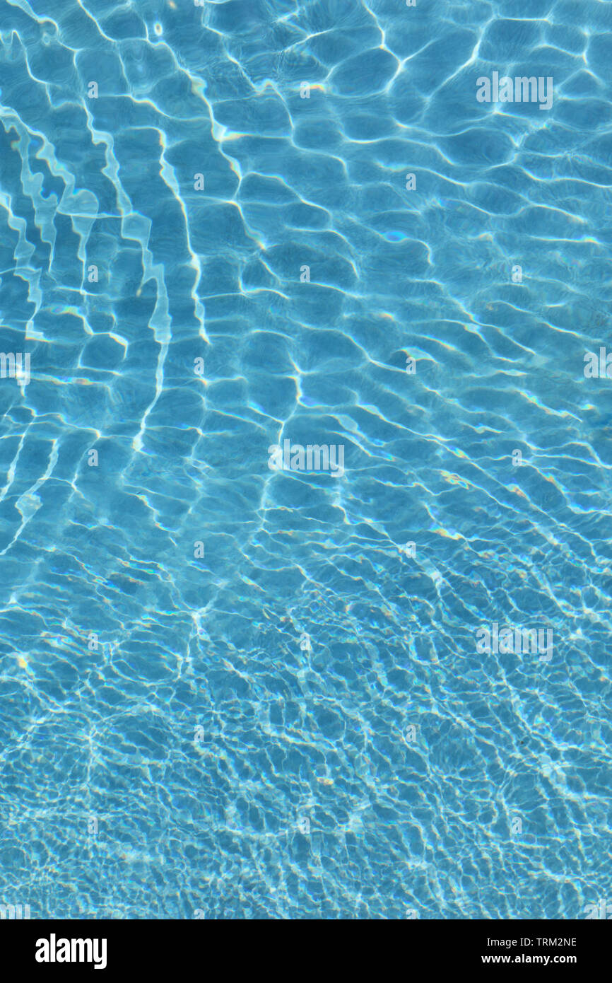 Small ripples on the surface of a swimming pool dissipating Stock Photo