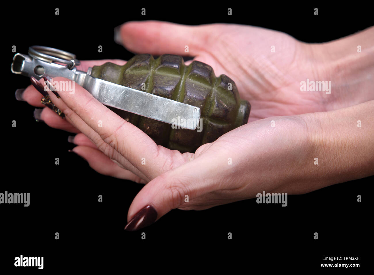 hand grenade in girl hand on black background Stock Photo