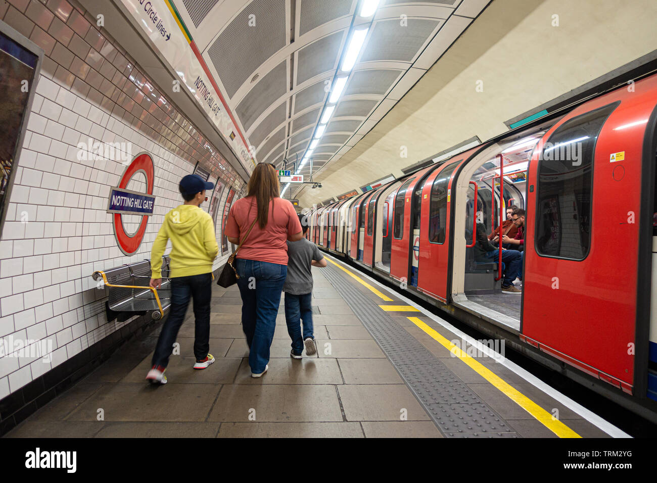 A mother and her son walk down the platform at Notting Hill Gate London Underground platform having arrived on a train. Stock Photo