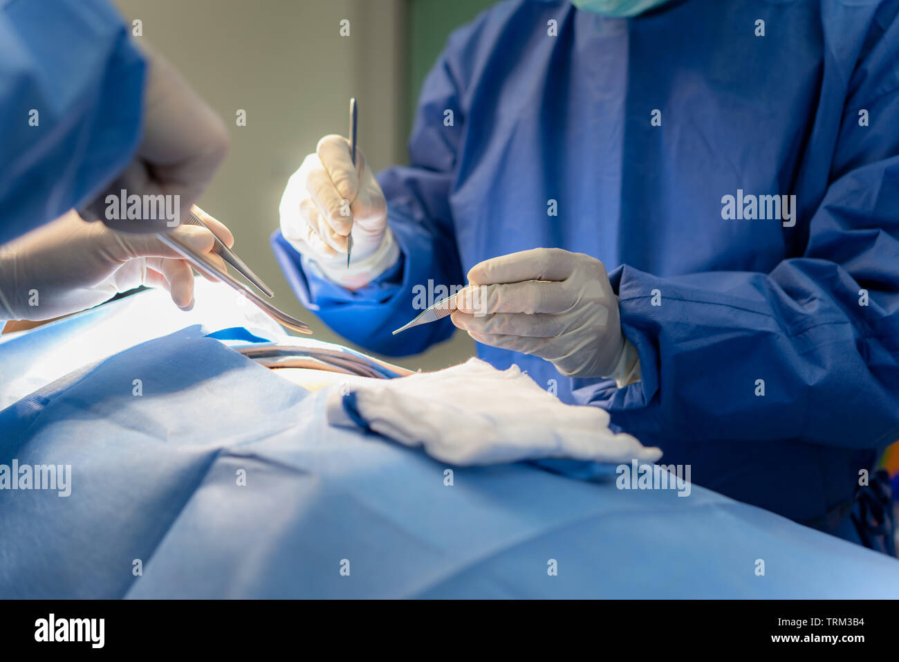 Group of surgeons at work in operating theater. Medical team performing operation Stock Photo