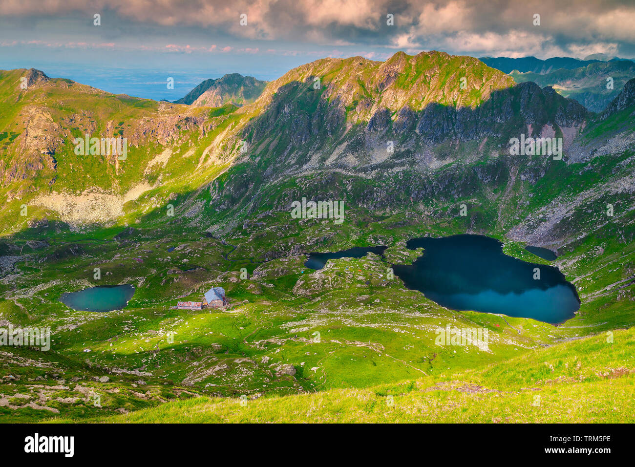 Stunning hiking place with high mountains and alpine lakes. Fantastic sunset landscape with green valley and mountain ponds, Fagaras mountains, Carpat Stock Photo