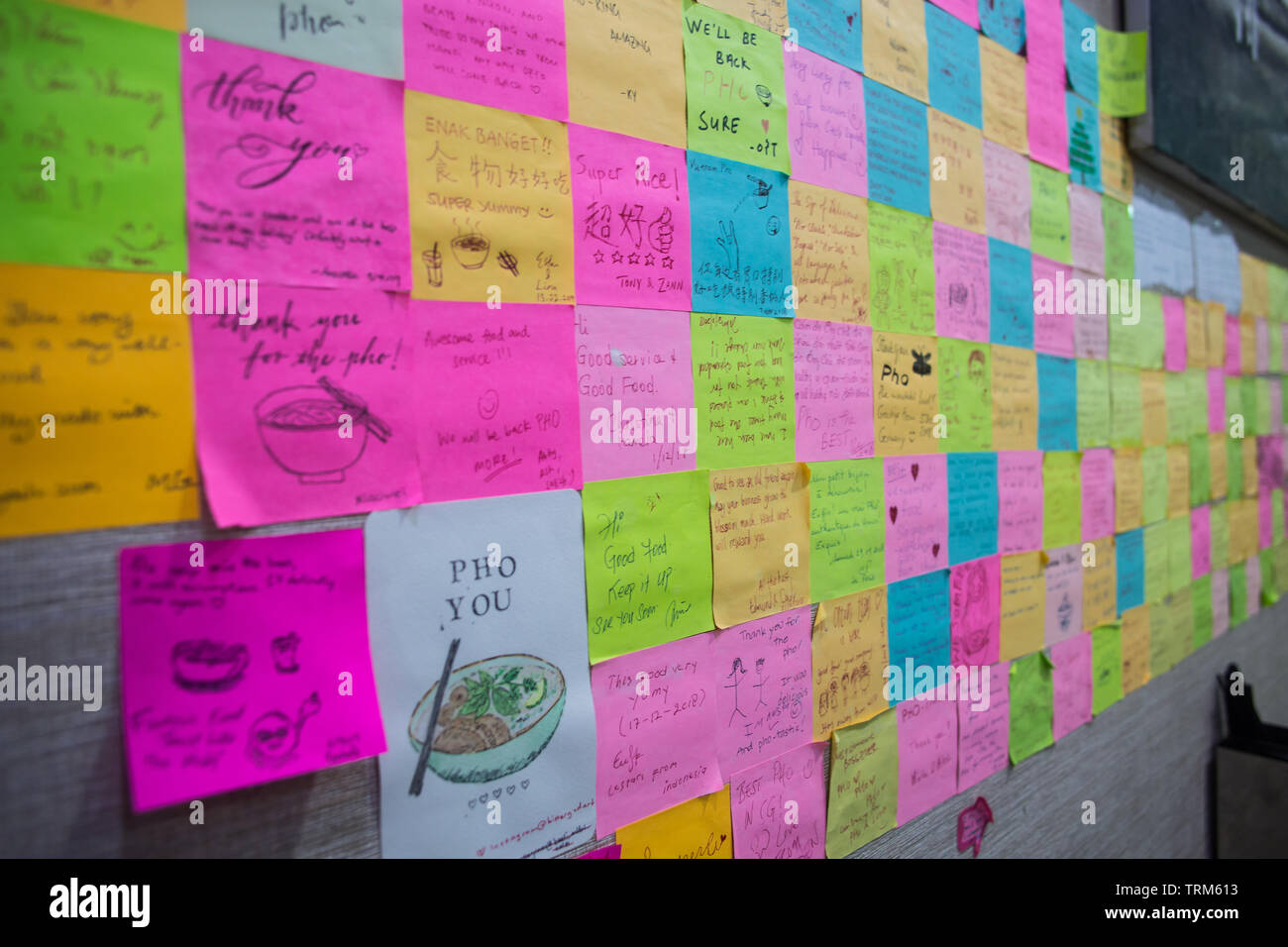 Sticky notes paste on the wall were written by patrons and travellers  around the world to give love to the restaurant Stock Photo - Alamy