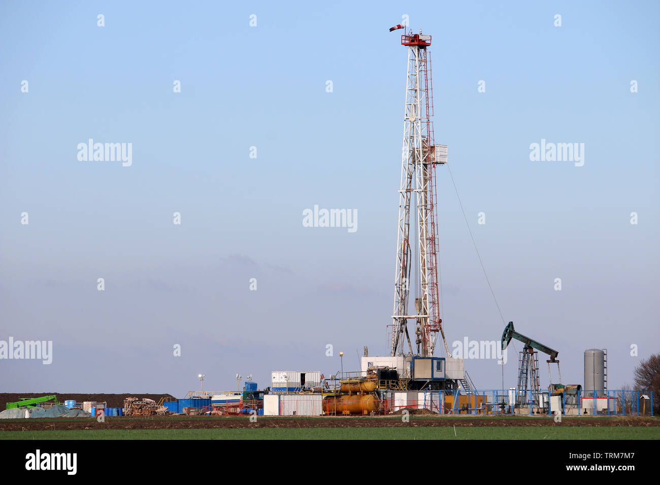Oil and gas drilling rig and pump jack in oilfield industry Stock Photo