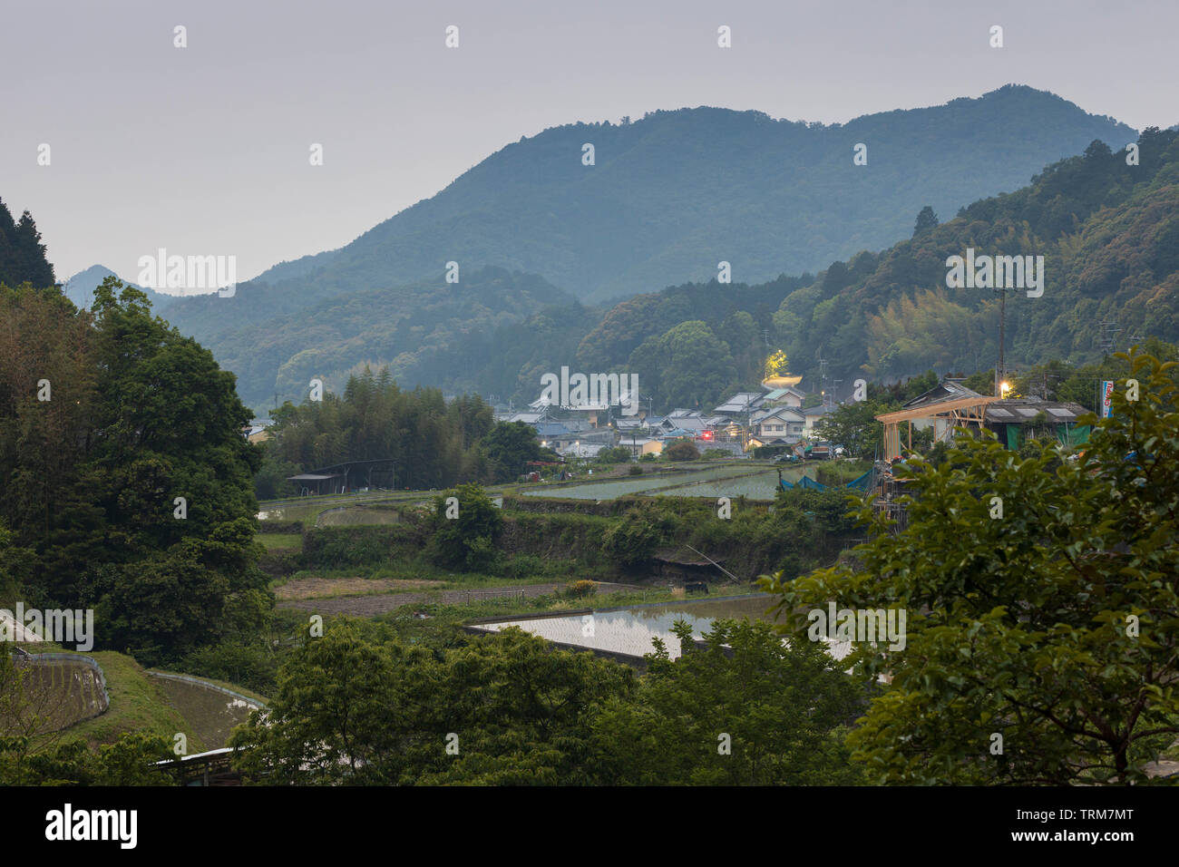 Rice fields and buildings in small Japanese mountain town at dusk Stock ...