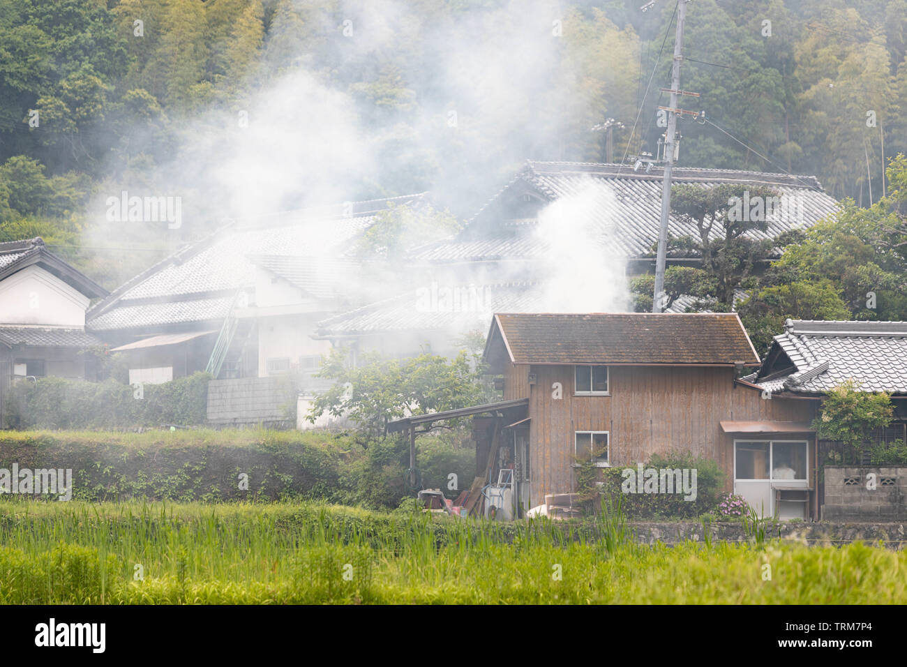Smoke billows from traditional Japanese farming village due to controlled burn Stock Photo