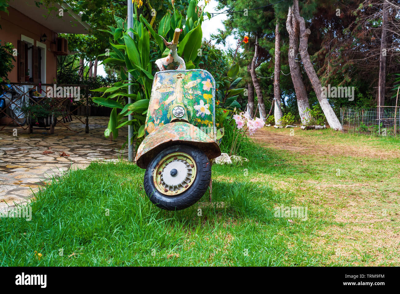 An old abandoned painted motorcycle in a garden at Corfu island, Greece ...