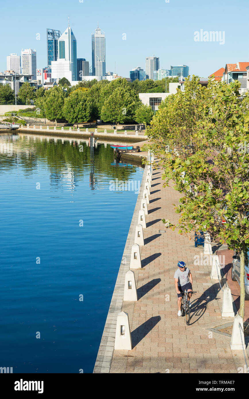 A man cycles along the embankment at Claisebrook Cove in East Perth, Western Australia. Stock Photo