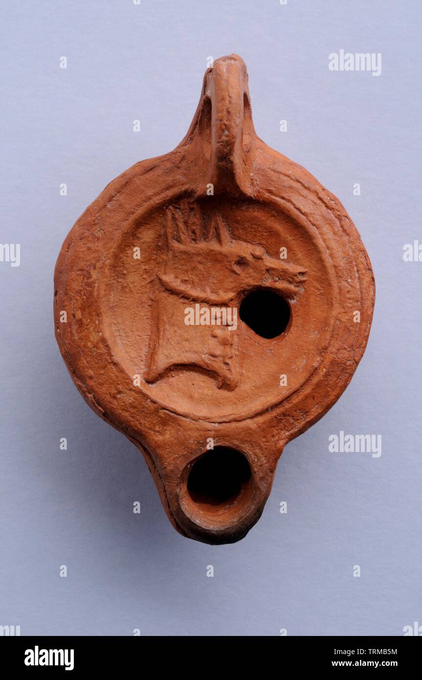 Lucerna de disco decorada con caballo en relieve. 7,2 cms x 5cms (Siglo I-II  dc ) - Epoca romana , procedente del Yacimiento arqueológico de Complutu Stock Photo