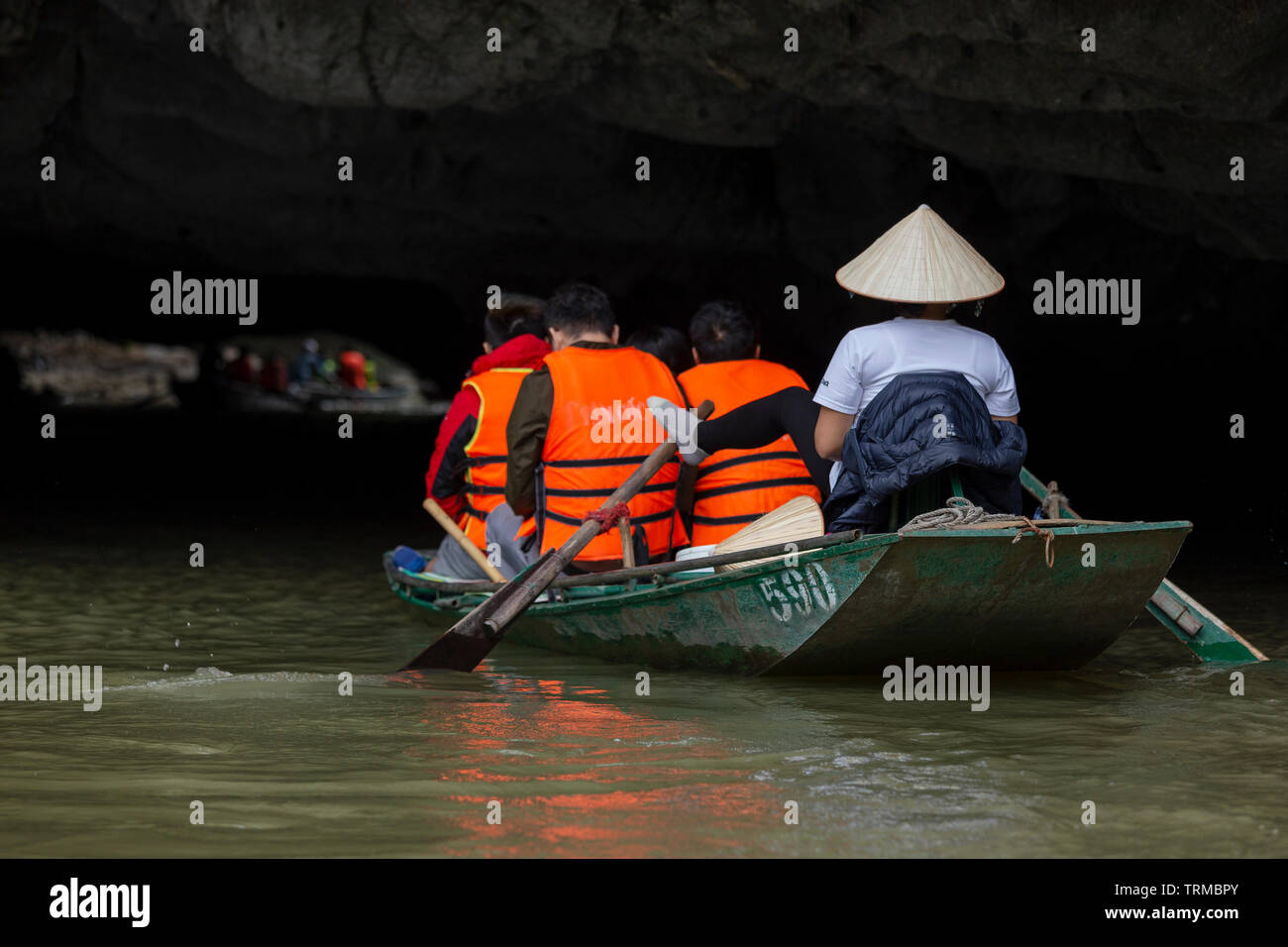 NINH BINH, VIETNAM - FEBRUARY 2019; Tourists In Rowboats Pass Through A Cave In Tam Coc Stock Photo